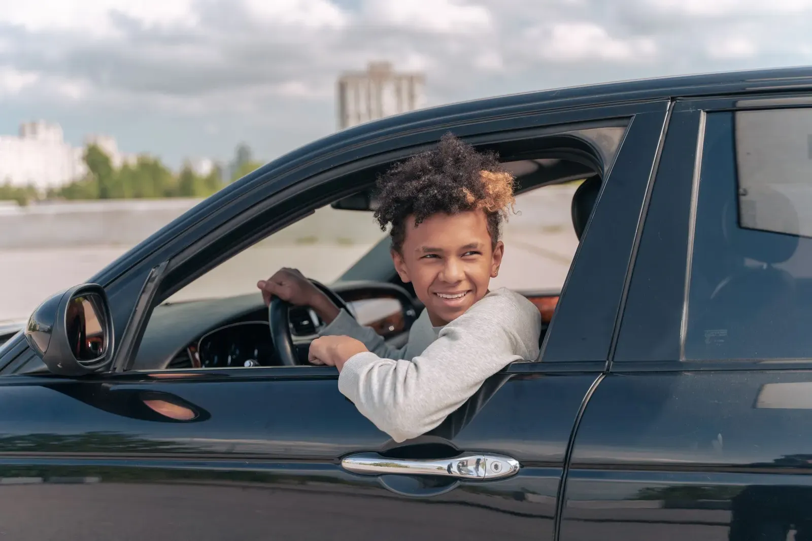 Jugendlicher lächelt am Steuer eines Autos