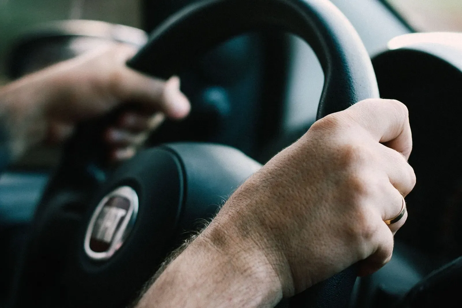 Junge Frau lächelt aus dem Fenster ihres Autos
